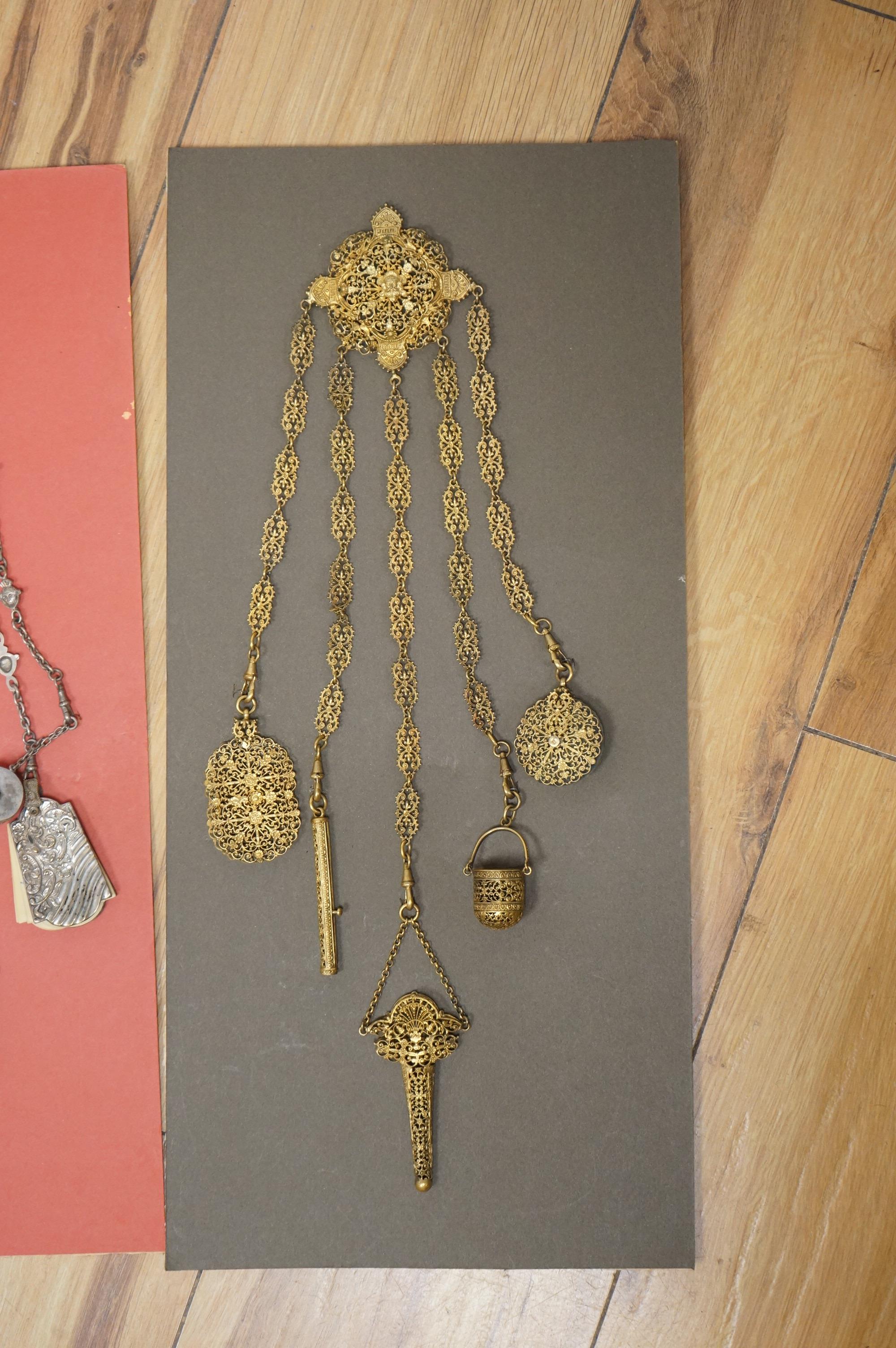 Four assorted 19th century base metal chatelaines, one with some silver implements